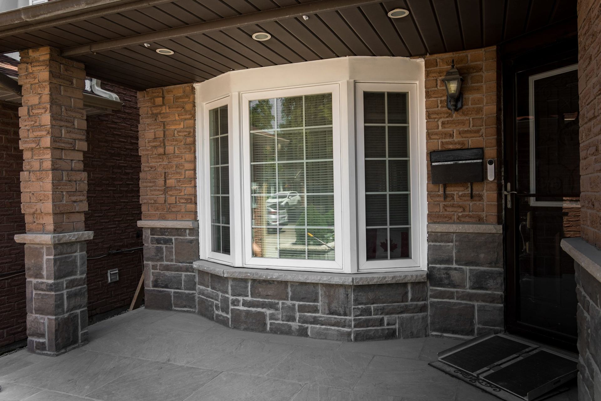 Concrete porch landing surrounded by stone masonry